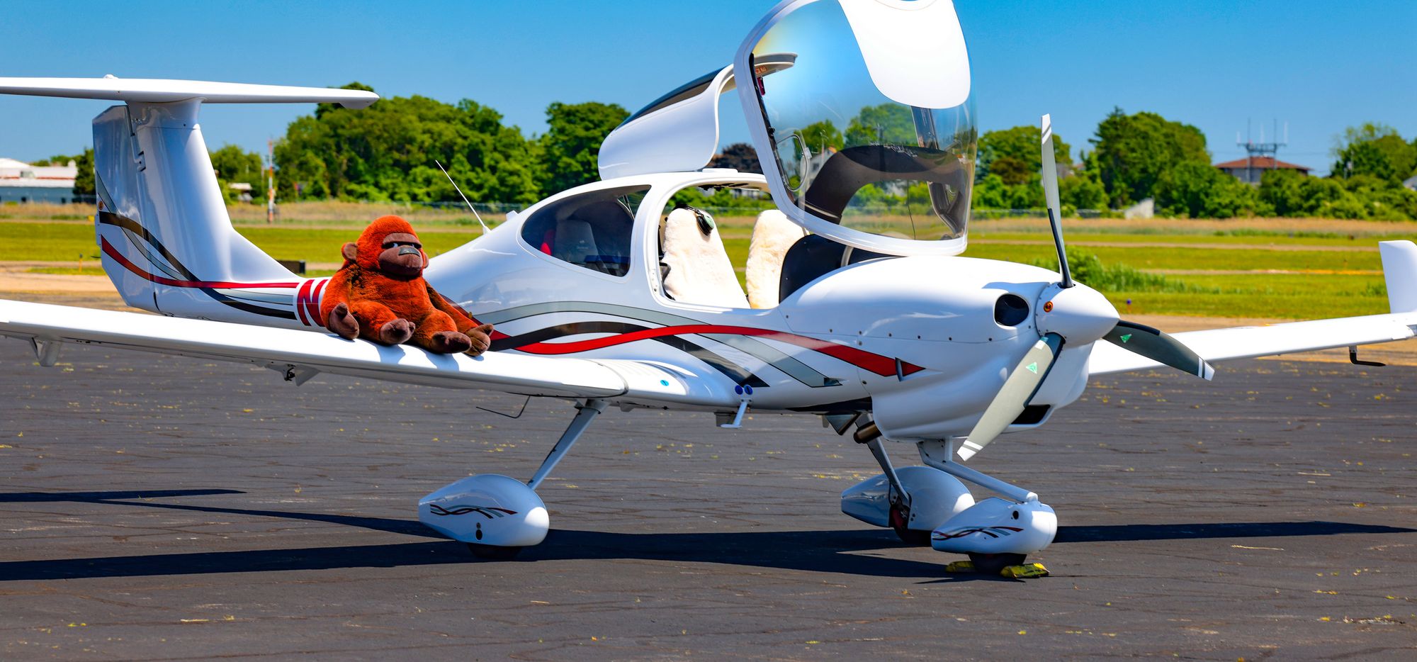 N115NG on the ramp at Boire Field, canopy open, with William seated on the wing